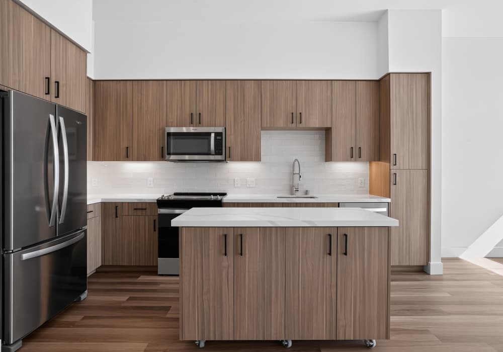 Kitchen with wood cabinets, stainless appliances and quartz island at The Colton in Redwood City, California
