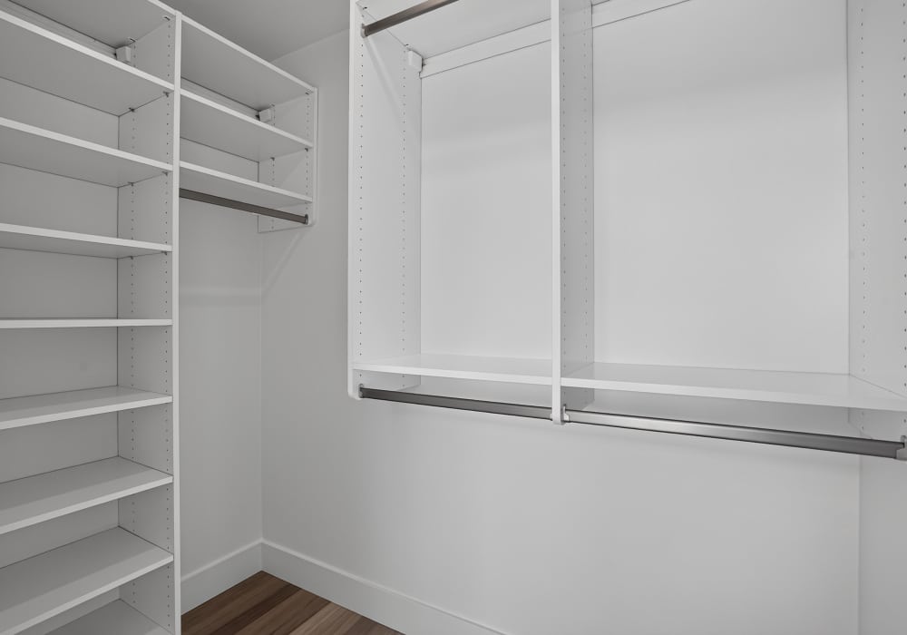 Walk-in closet with white shelving and double hanging rods at The Colton in Redwood City, California