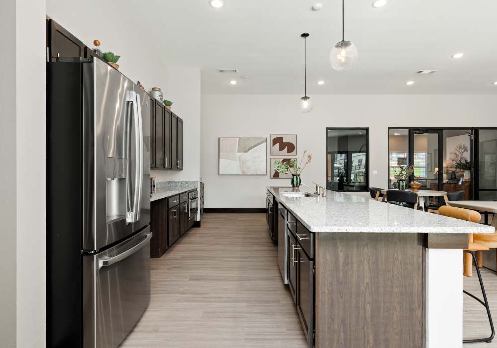 Model home kitchen featuring a large island and stainless steel appliances at Oak Creek in New Braunfels, Texas