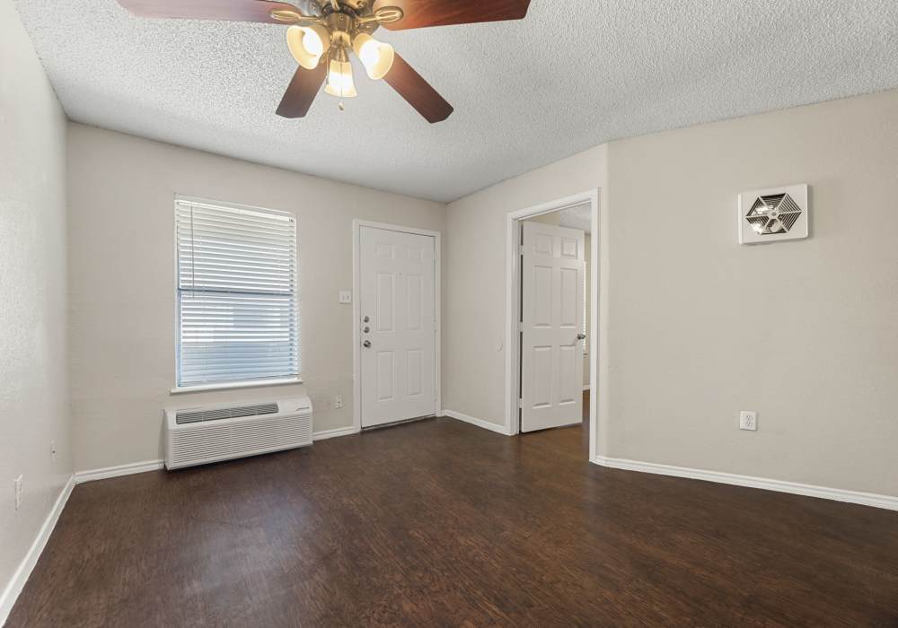 Kitchen corner with gray cabinets, tile backsplash, sink and white refrigerator at Country Oaks in Weatherford, Texas