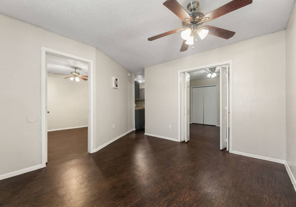 Empty room with entry door, window unit air conditioner and ceiling fan at Country Oaks in Weatherford, Texas
