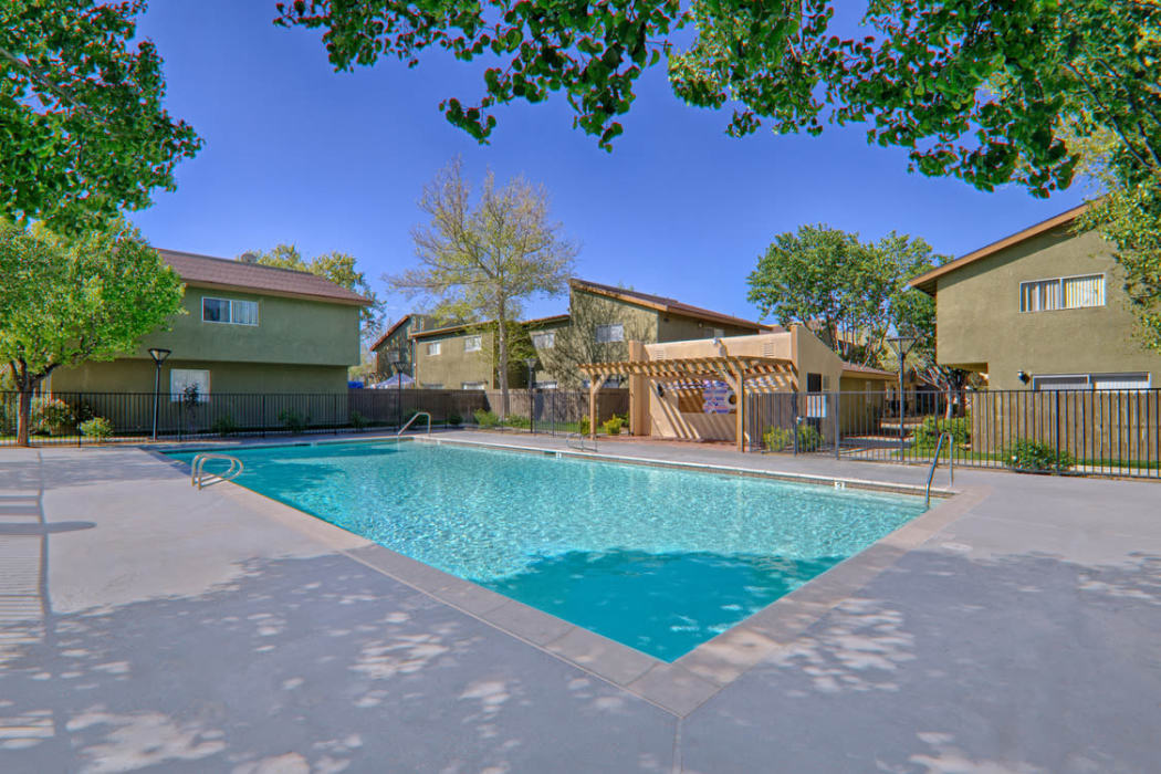 Beautiful sparkling swimming pool on a sunny day at Woodlands West Apartment Homes in Lancaster, CA