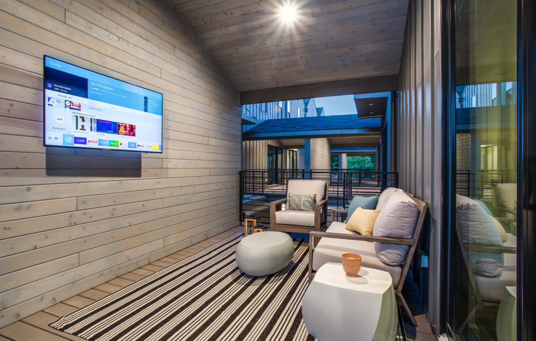 Resident lounge with seating and large television at The Collection Townhomes in Dallas, Texas
