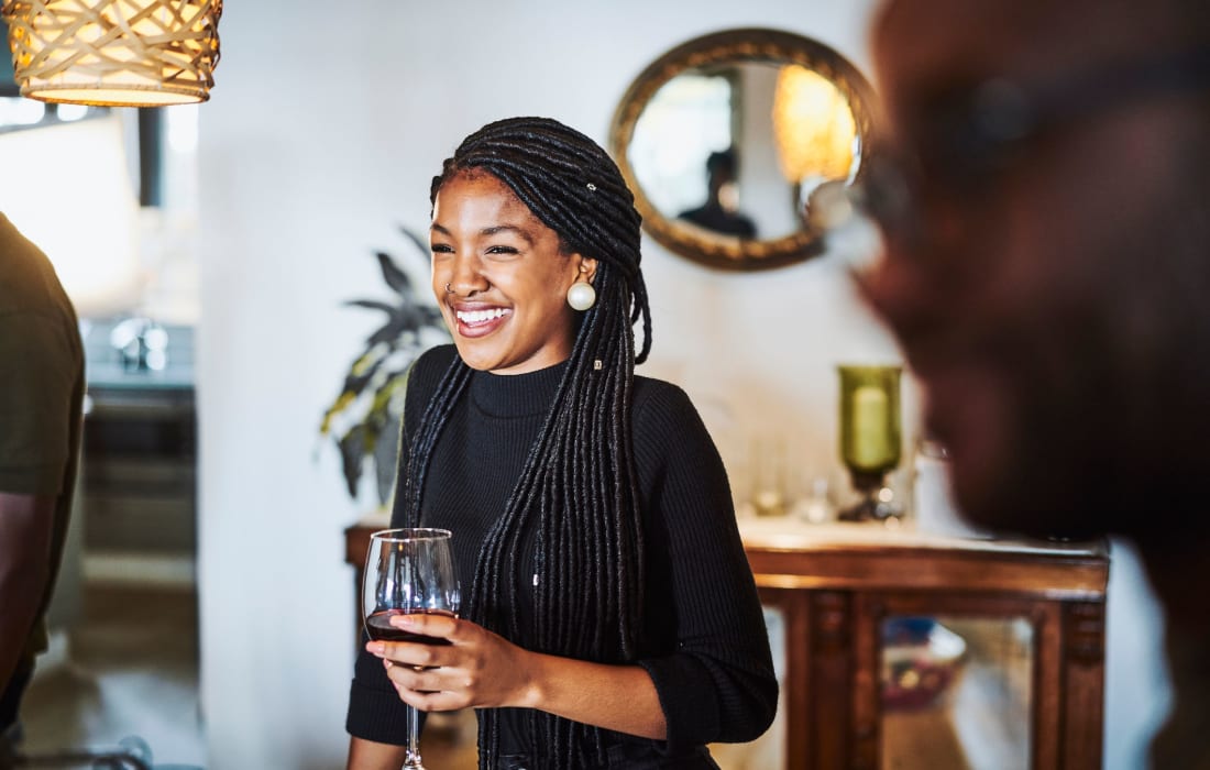 Woman smiling while socializing and drinking wine at The Collection Townhomes in Dallas, Texas