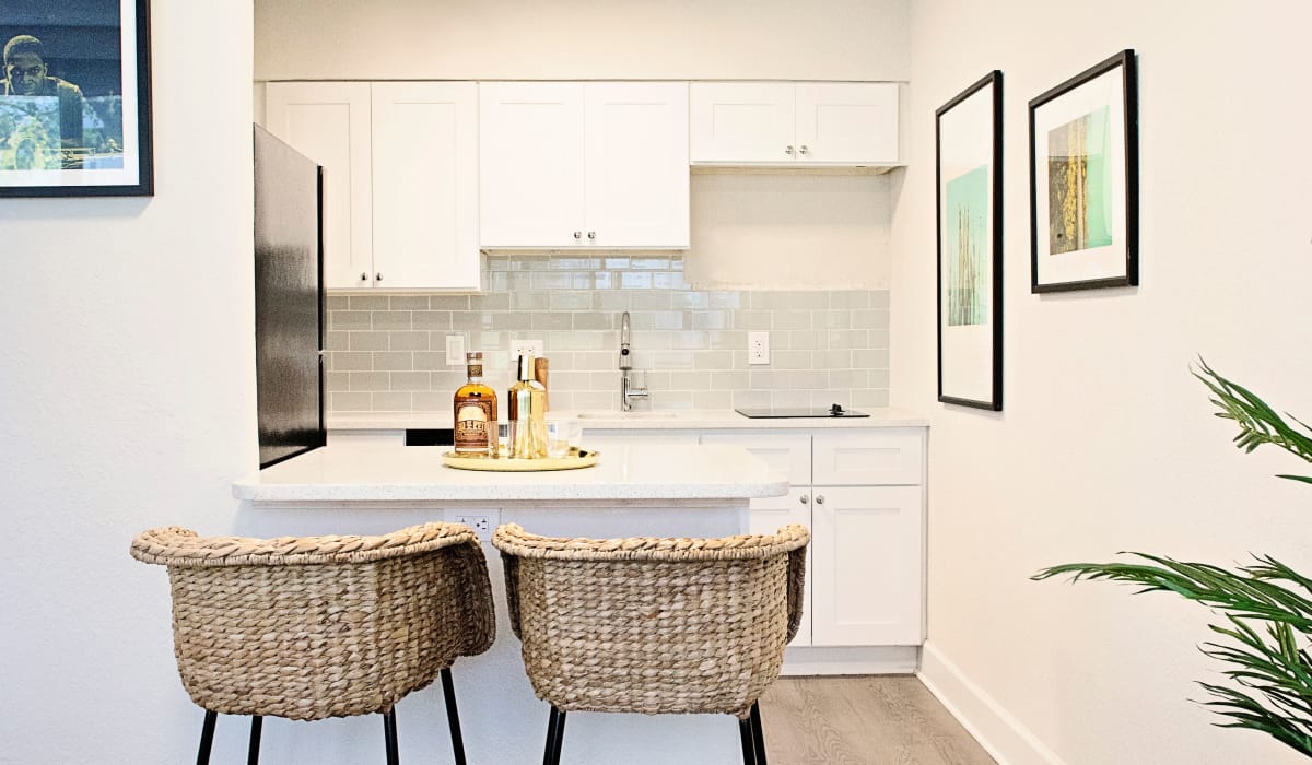 Bright, modern kitchen with white cabinetry and breakfast bar in model home at The Wayland in St Petersburg, Florida