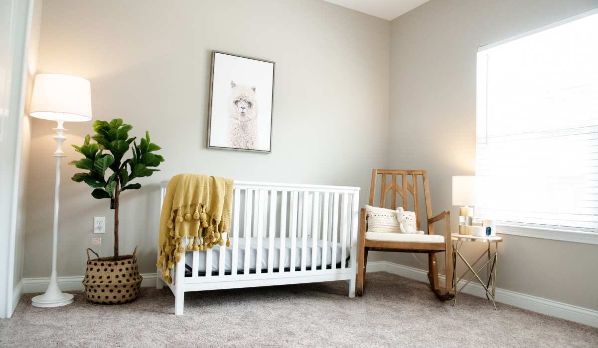Bedroom with a crib and rocking chair at Bonterra Apartments in Fort Wayne, Indiana