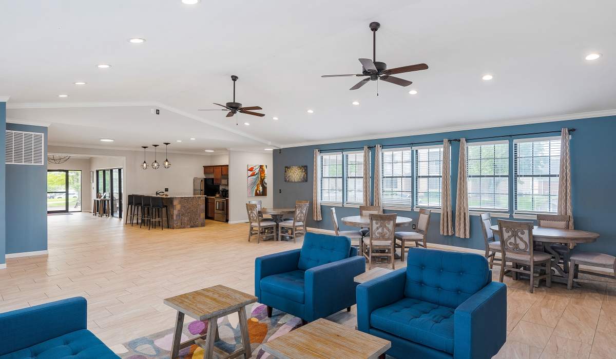 Bright community lounge with blue chairs at Burlington Oaks in Burlington, Kentucky