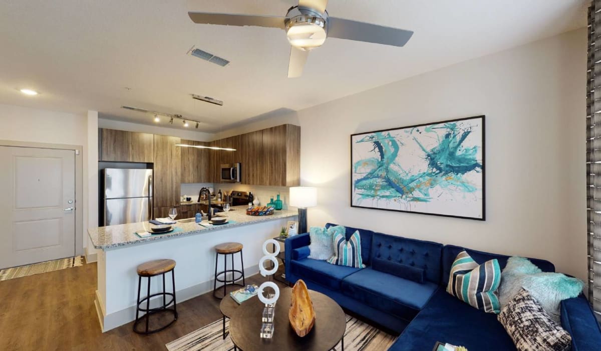 Open concept living room next to kitchen area with counter seating at Soba Apartments in Jacksonville, Florida
