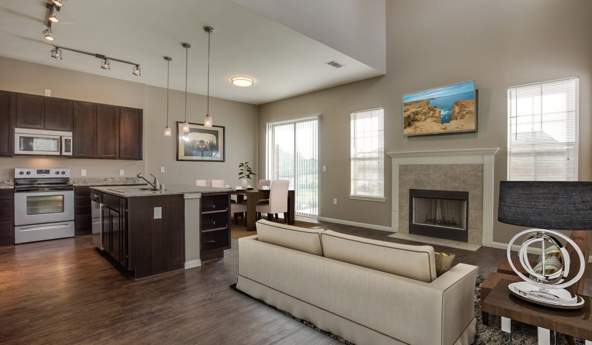 Modern kitchen with an island, quartz countertops, and custom wood cabinetry in a model apartment at Parkside Towns in Richardson, Texas