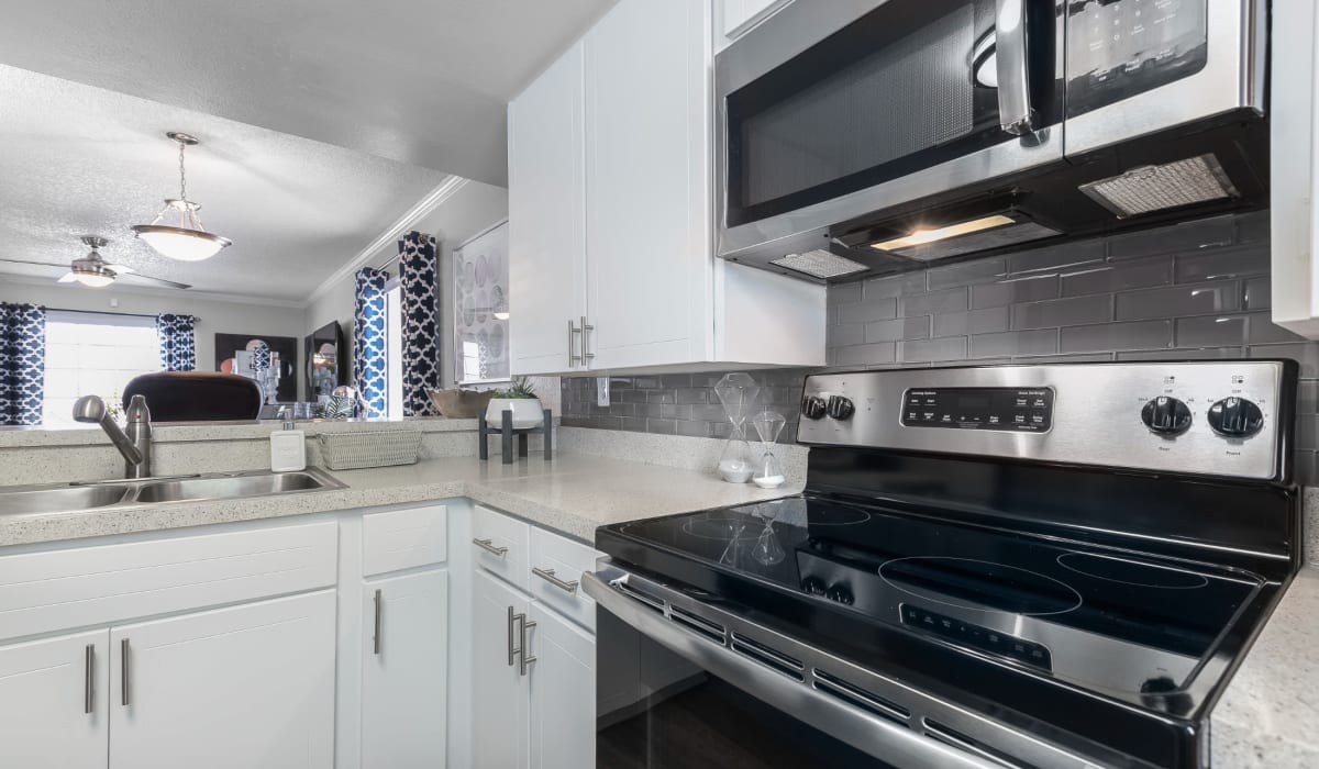 Kitchen with white cabinets and stainless steel appliances at Barrington Place at Winter Haven in Winter Haven, Florida