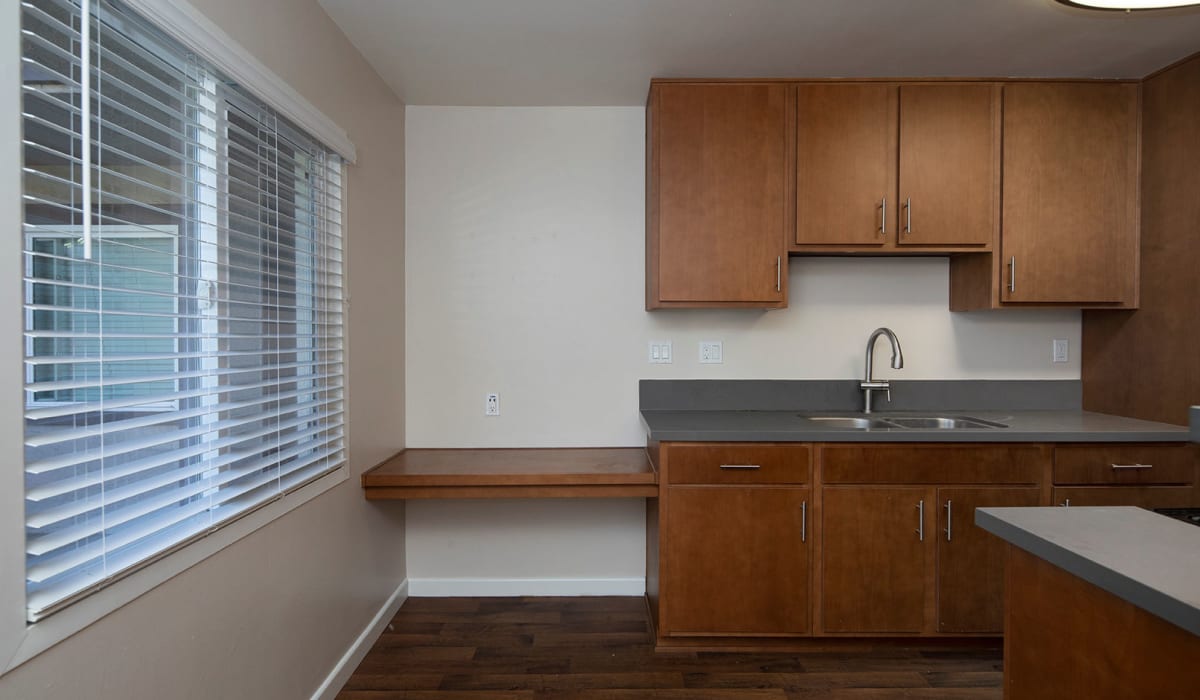 Model kitchen with wood cabinets at Playa Apartments in San Diego, California