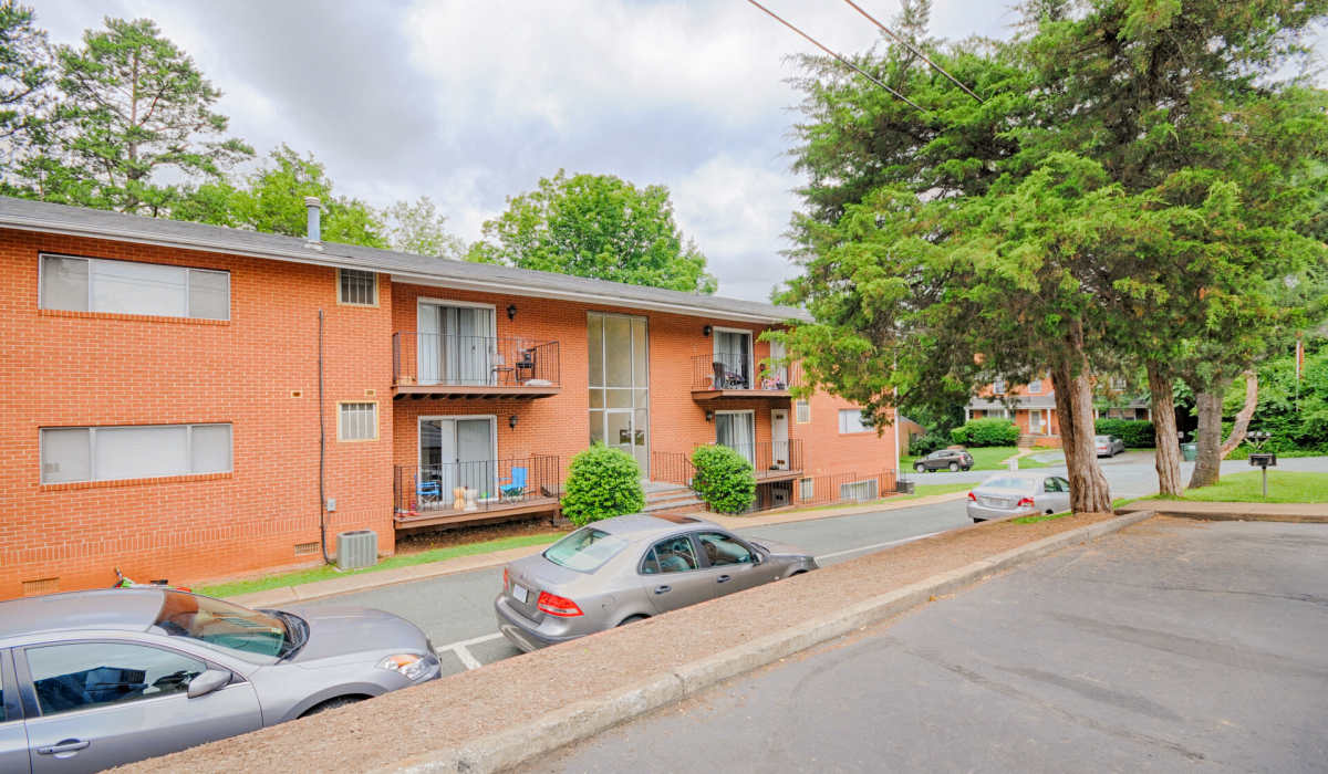 View of apartment's patio and parking area at Berkshire and Barter Court Apartments in Charlottesville, Virginia