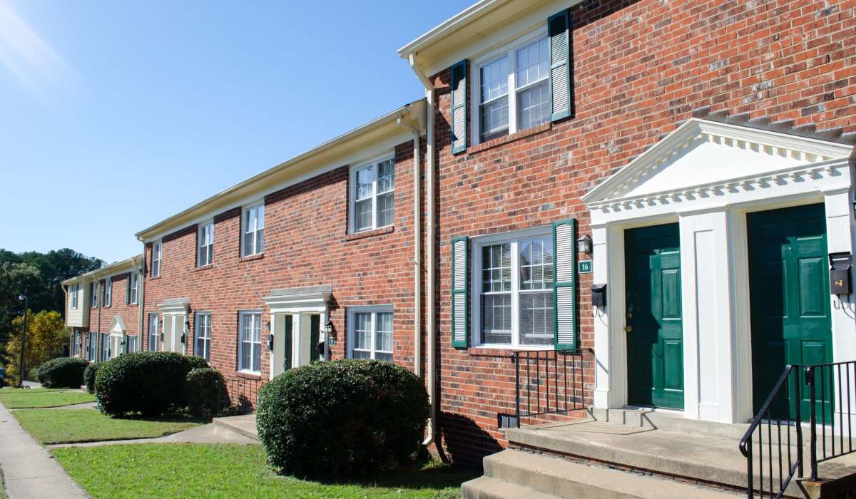 View of exterior of apartments and green lawn at Landmark at Patterson in Richmond, Virginia