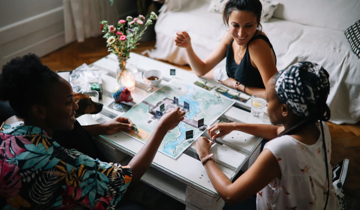 Group of friends playing a board game in their apartment at The Collection Townhomes in Dallas, Texas