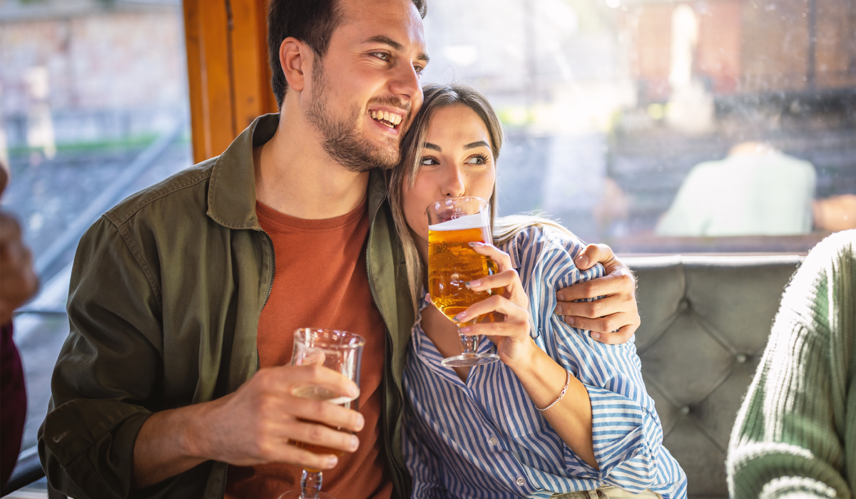 Couple enjoying beers at a restaurant at The Collection Townhomes in Dallas, Texas