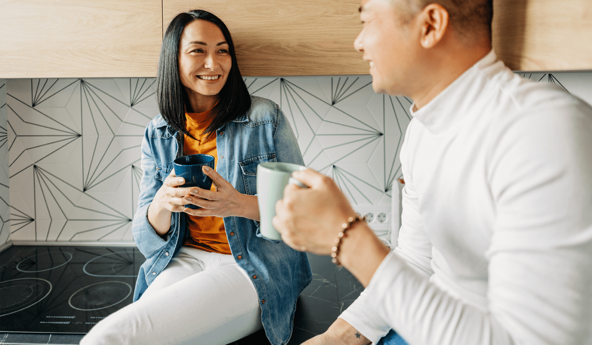 Friends enjoying coffee in their apartment kitchen at The Collection Townhomes in Dallas, Texas