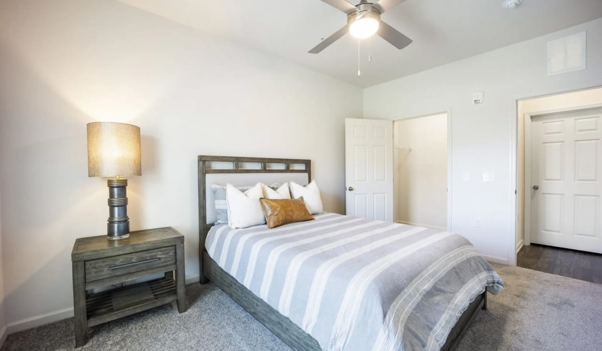A cozy spare bedroom with a closet in a model home at The Maddox in Centerton, Arkansas