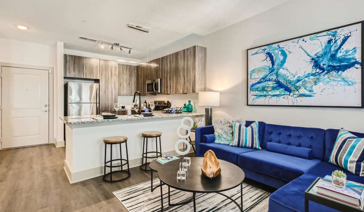 Open concept living room next to kitchen area with counter seating at SoBA Apartments in Jacksonville, Florida