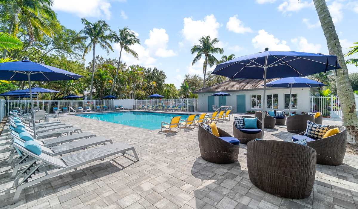 Outdoor patio seating by the pool at Boynton Place Apartments in Boynton Beach, Florida