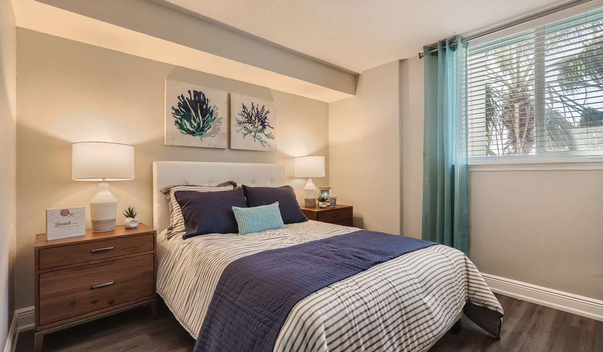 Spacious bedroom with window and matching end tables at Waters Pointe in South Pasadena, Florida