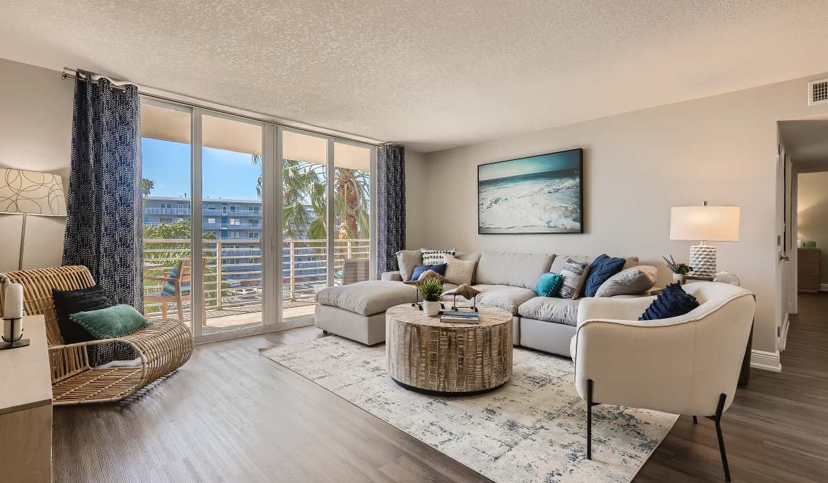 Living room with wood-style flooring opening onto a private balcony with stunning views of the bay at Waters Pointe in South Pasadena, Florida