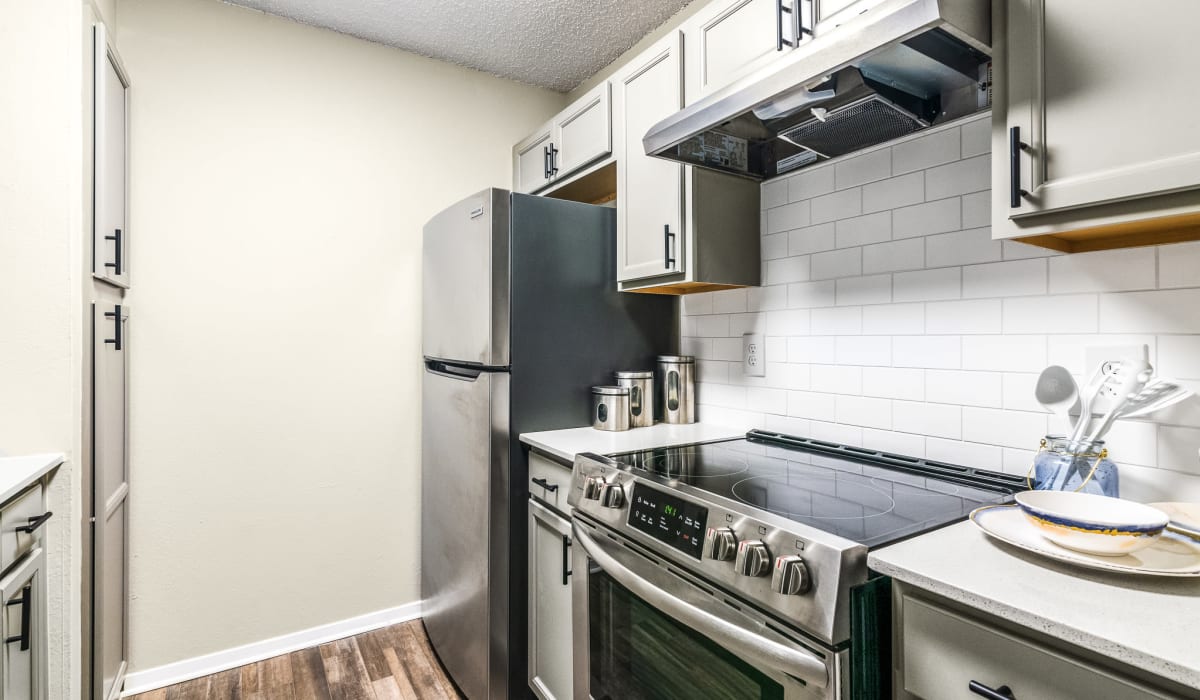 Compact Kitchen Featuring Stainless Steel Appliances  at Holbrook Apartment Homes in Dallas, Texas