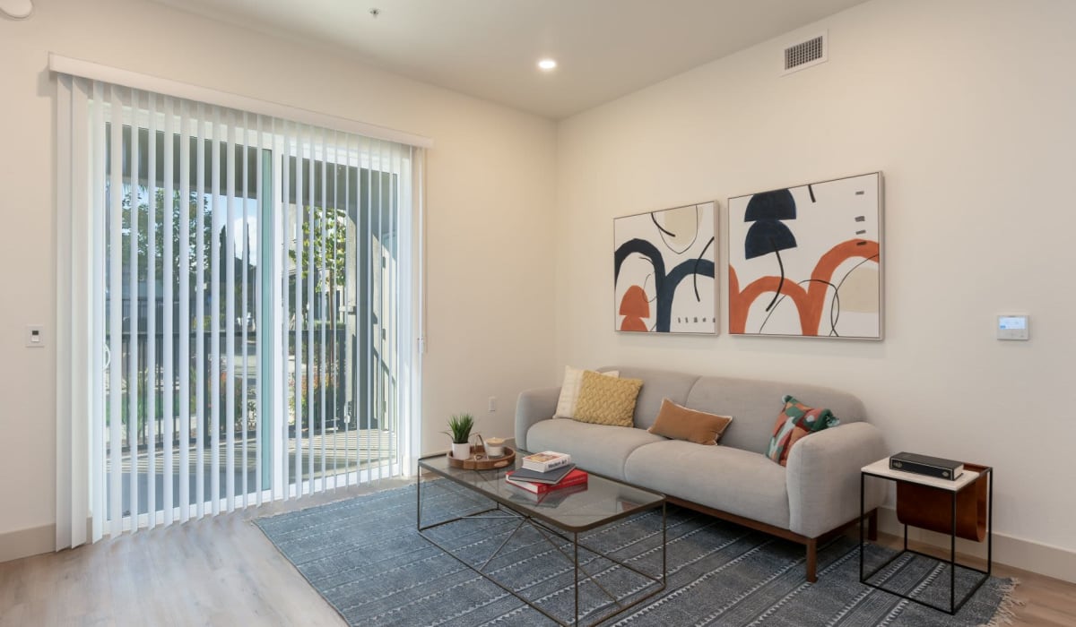 Living room with sliding doors to patio at Towne Centre Apartments in Lathrop, California