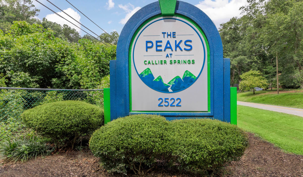 Exterior sign with lush landscaping at The Peaks at Callier Springs in Rome, Georgia