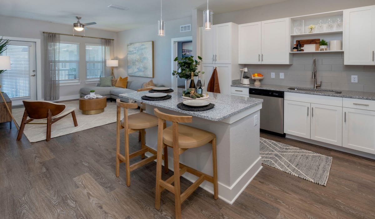 An apartment kitchen with an island and the living room at Sentosa Riverview in Riverview, Florida