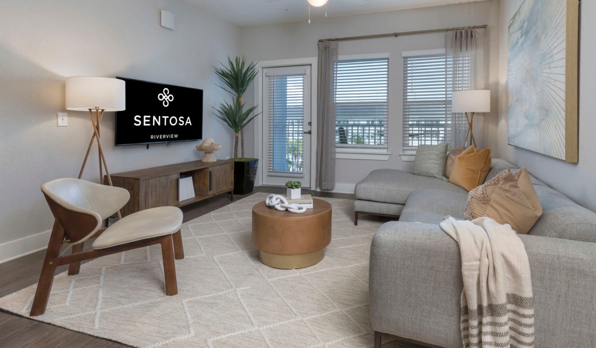 A furnished apartment living room with access to the balcony at Sentosa Riverview in Riverview, Florida