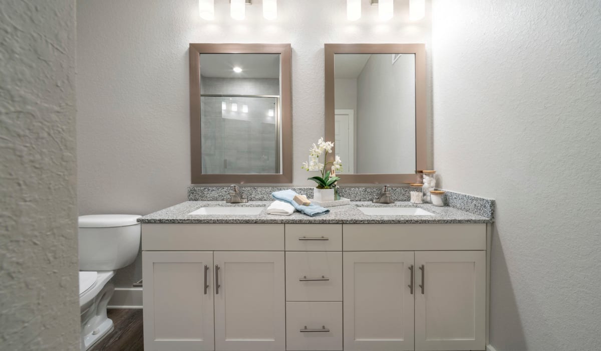 A double vanity with a marble countertop in an apartment bathroom at Sentosa Riverview in Riverview, Florida