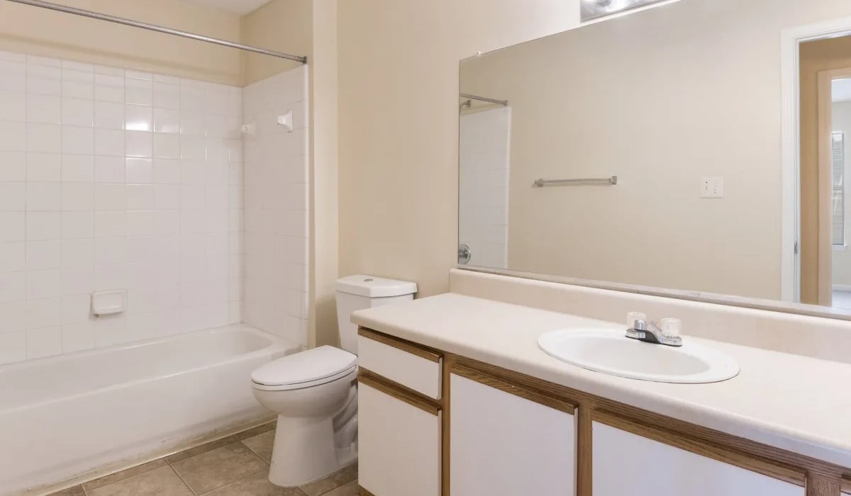 White cabinets and a full-sized bathtub in an apartment bathroom at St. Phillip Villas in Griffin, Georgia