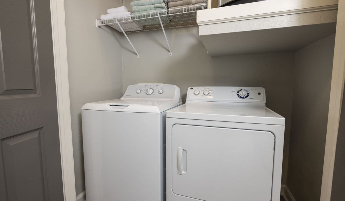 A full-sized washer and dryer in an apartment laundry room at Evergreen at Tuscany Villas in Baton Rouge, Louisiana