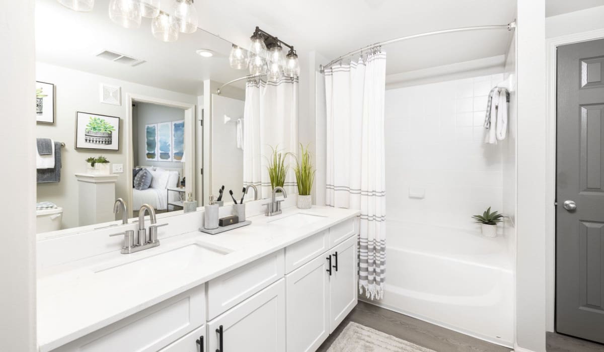 A large double vanity and full-sized bathtub in an apartment bathroom at Evergreen at Tuscany Villas in Baton Rouge, Louisiana