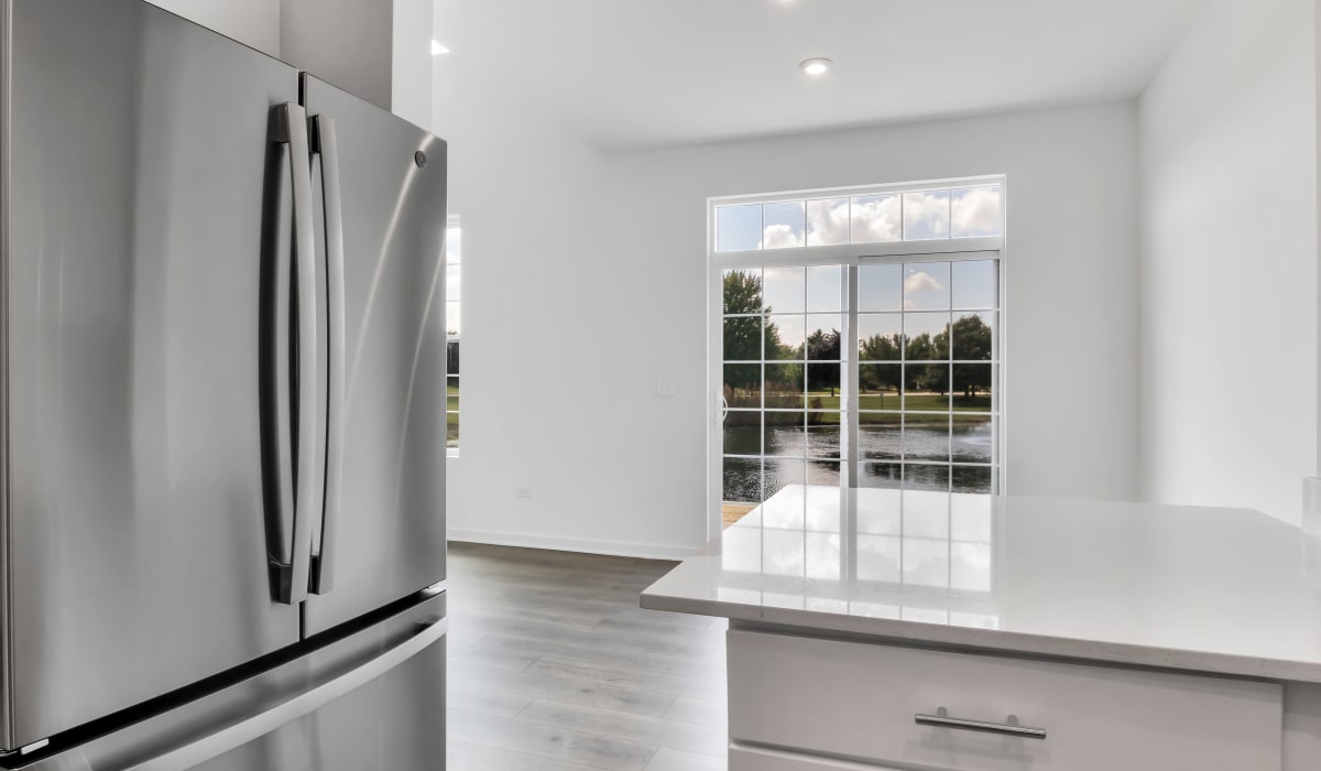 Stainless-steel fridge and an island in a kitchen at Home at Ashcroft in Oswego, Illinois