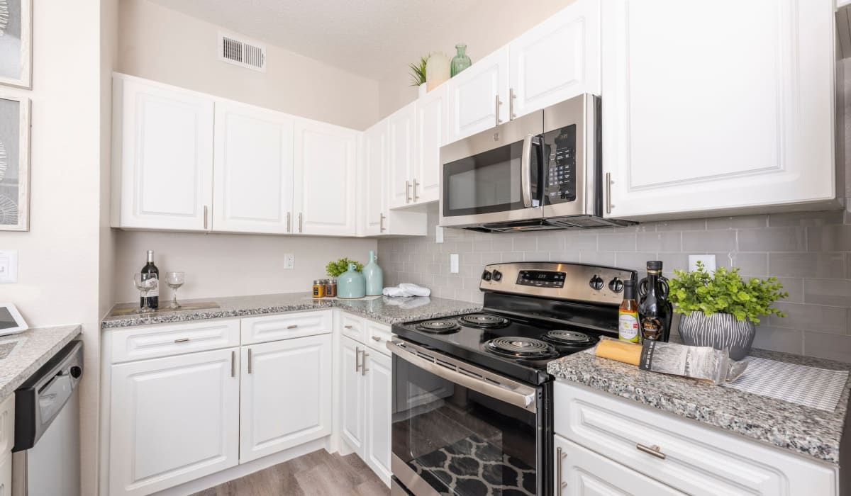 Kitchen with white cabinets at Gardens of Valley Ranch in Irving, Texas