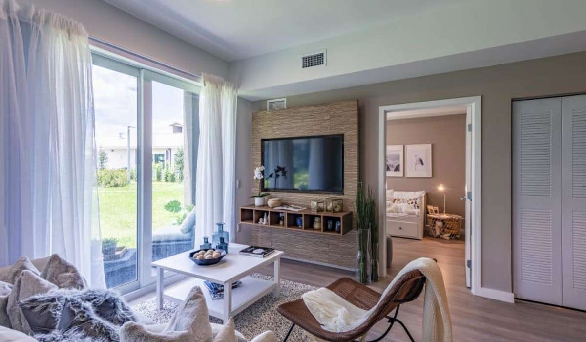 Living room with attached balcony at Palm Beach Preserve in West Palm Beach, Florida
