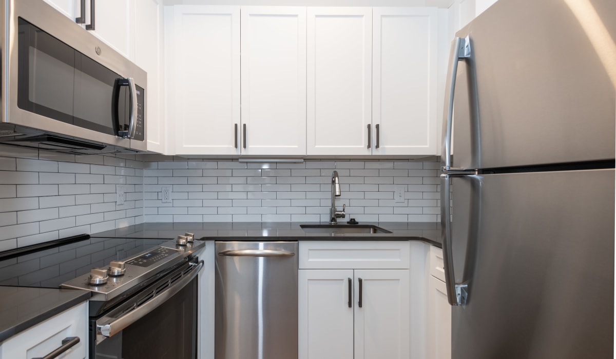 Apartment kitchen with white cabinets and major appliances at One India Street Apartments in Boston, Massachusetts