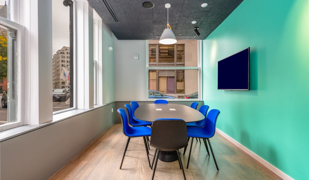 Community meeting space with large table and chairs at One India Street Apartments in Boston, Massachusetts