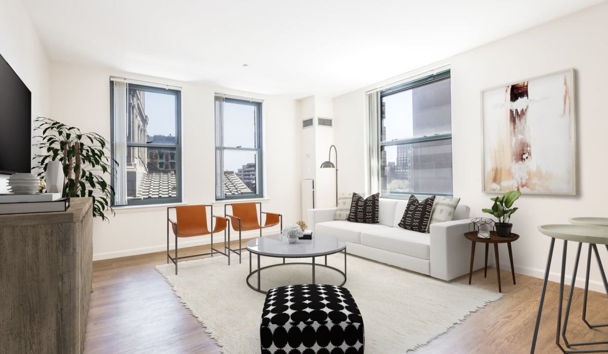 Apartment living room with large area rug and gray sofa at One India Street Apartments in Boston, Massachusetts