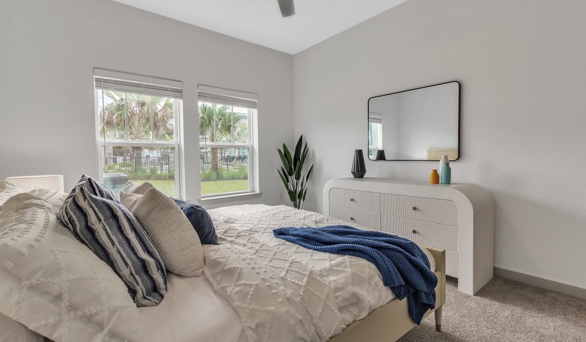 An apartment bedroom with a well-made bed and dresser at Avocet at Melbourne in Melbourne, Florida