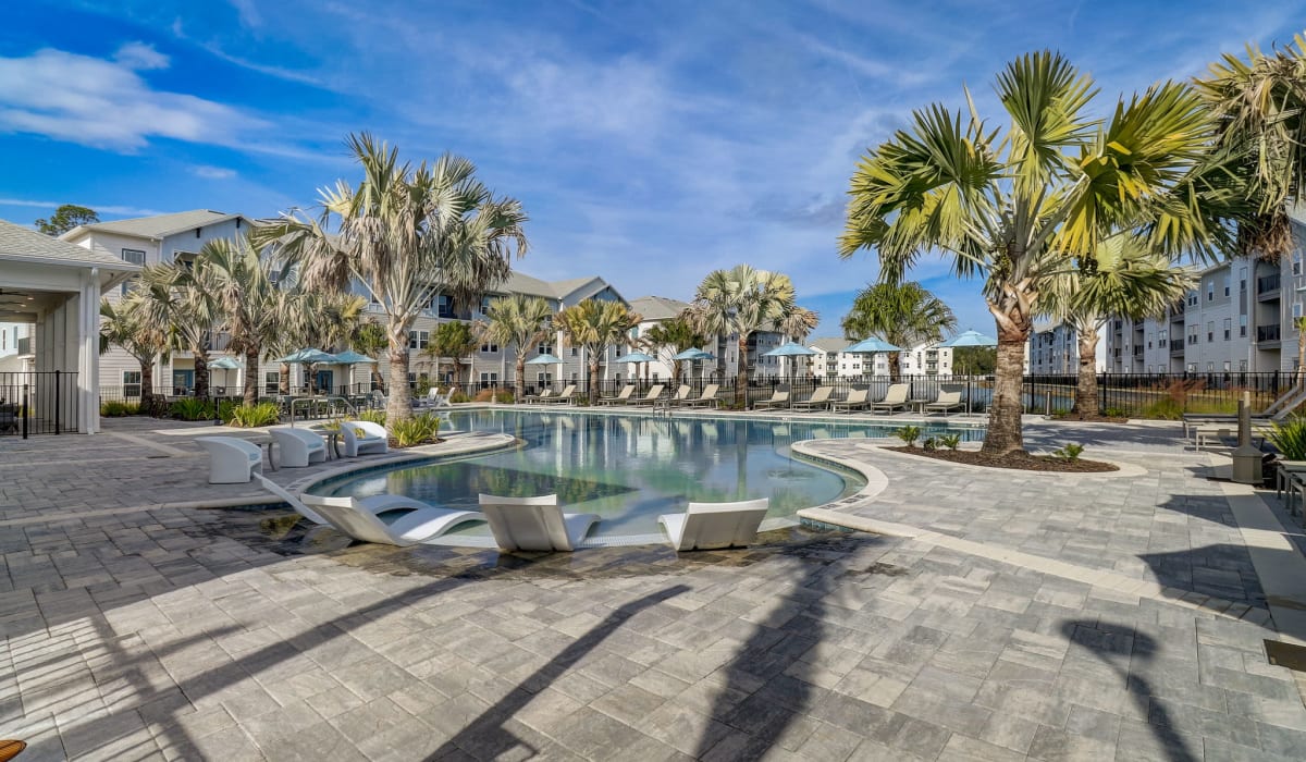 The community pool surrounded by palm trees at Avocet at Melbourne in Melbourne, Florida
