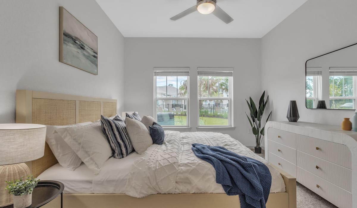 A furnished bedroom with a ceiling fan at Avocet at Melbourne in Melbourne, Florida