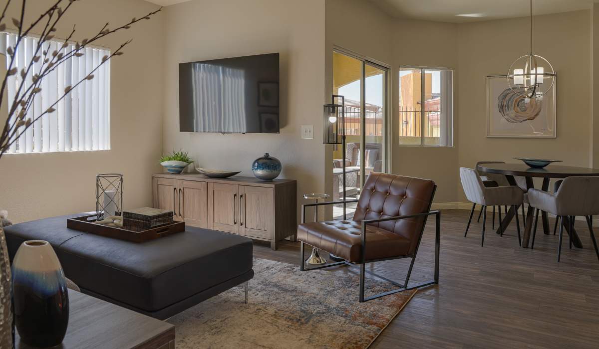 Model living room with wood floors and a tv at La Serena at the Heights in Henderson, Nevada