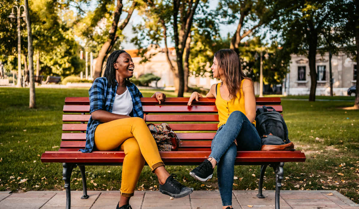 Friends sitting on bench near Villas by the Lake in Jonesboro, Georgia