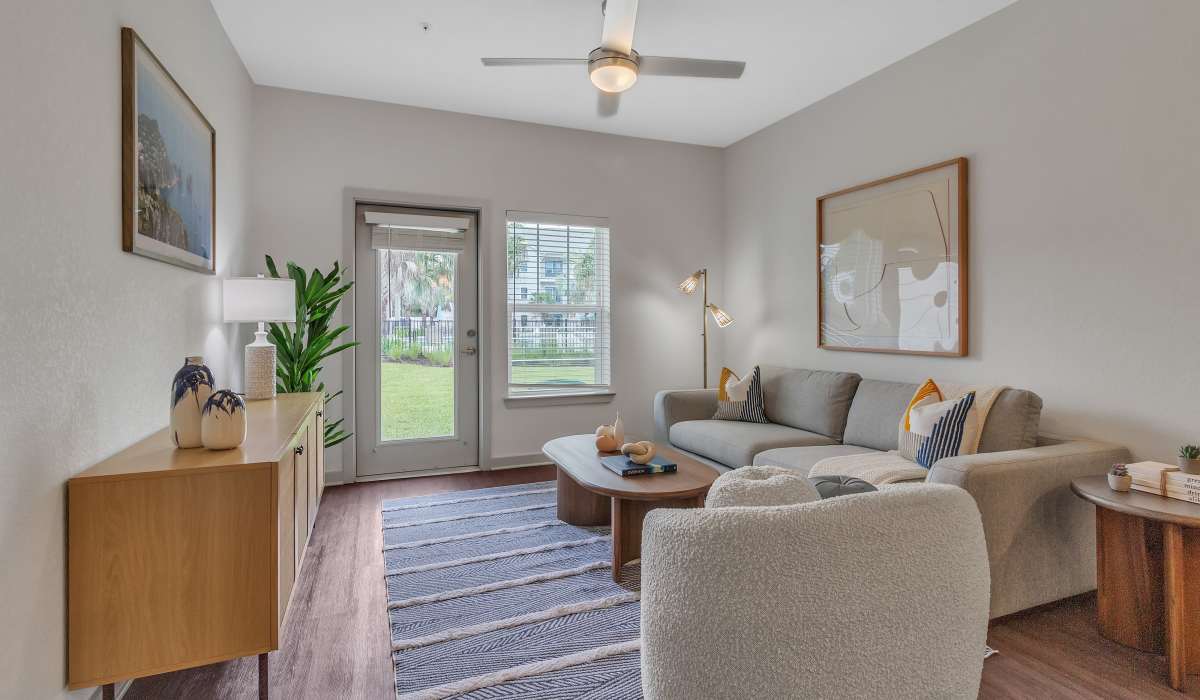 Living room with wood flooring and plenty of natural lighting in a model home at Seaton Preserve in Jacksonville, Florida