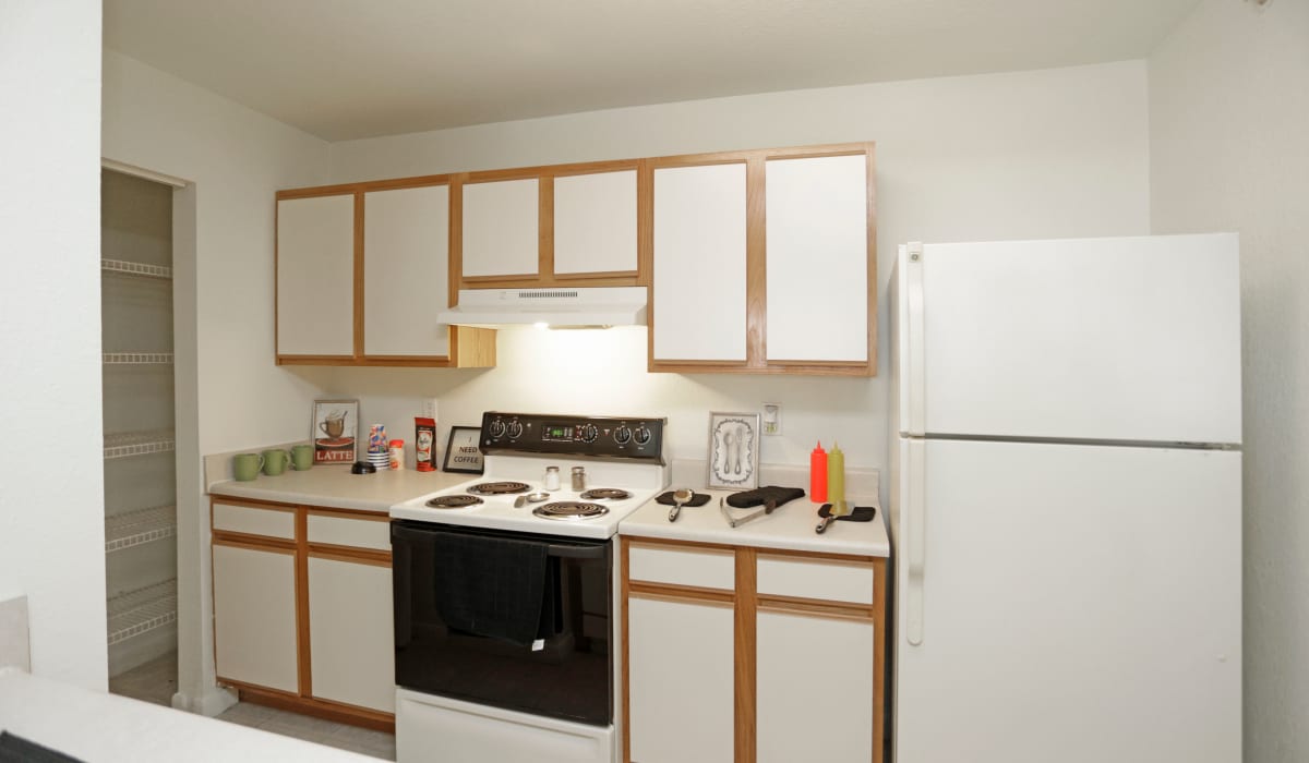 White appliances with wood cabinets at North Oak Crossing in Kansas City, Missouri
