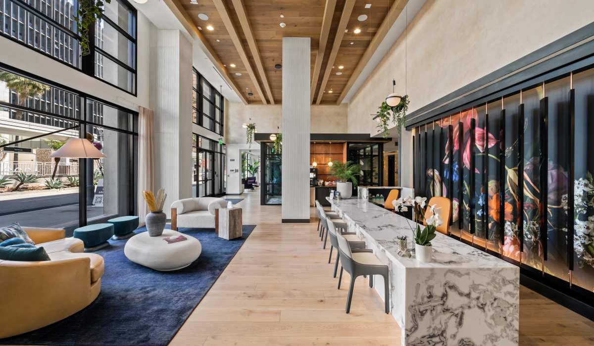 A hotel lobby with a vibrant mural depicting a captivating scene at Aster, Long Beach, California