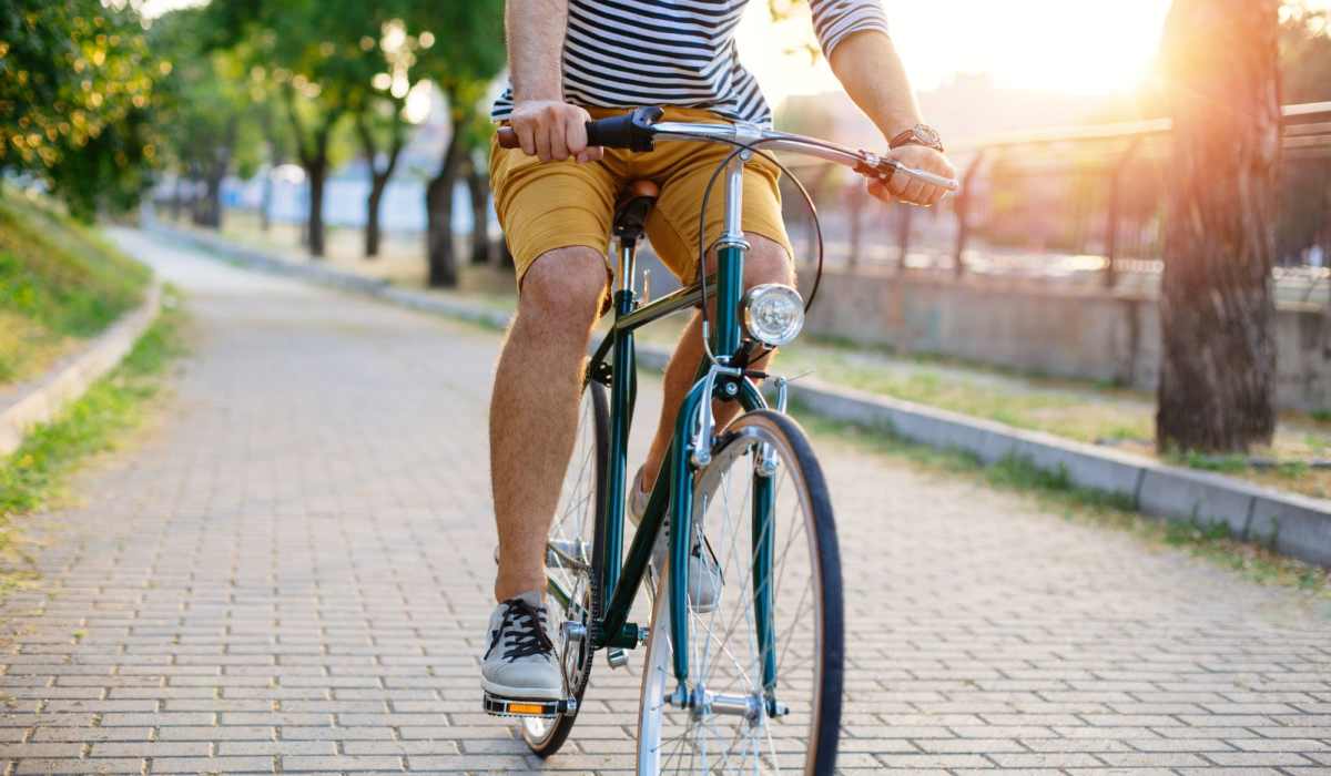 Resident riding a bicycle on a scenic path in the community at Grace and Monroe Apartments in Richmond, Virginia