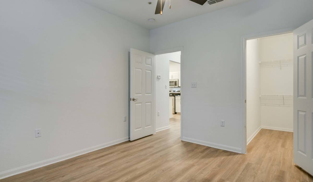 Empty bedroom with white interior adjacent to the bedroom and closet at Sole at Citrus Park in Tampa, Florida